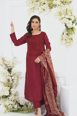 Video of a model in deep maroon tassar silk kurta with chevron pleated detailing and crystal sequins walks gracefully through white floral studio setting framed by roses and greenery.
